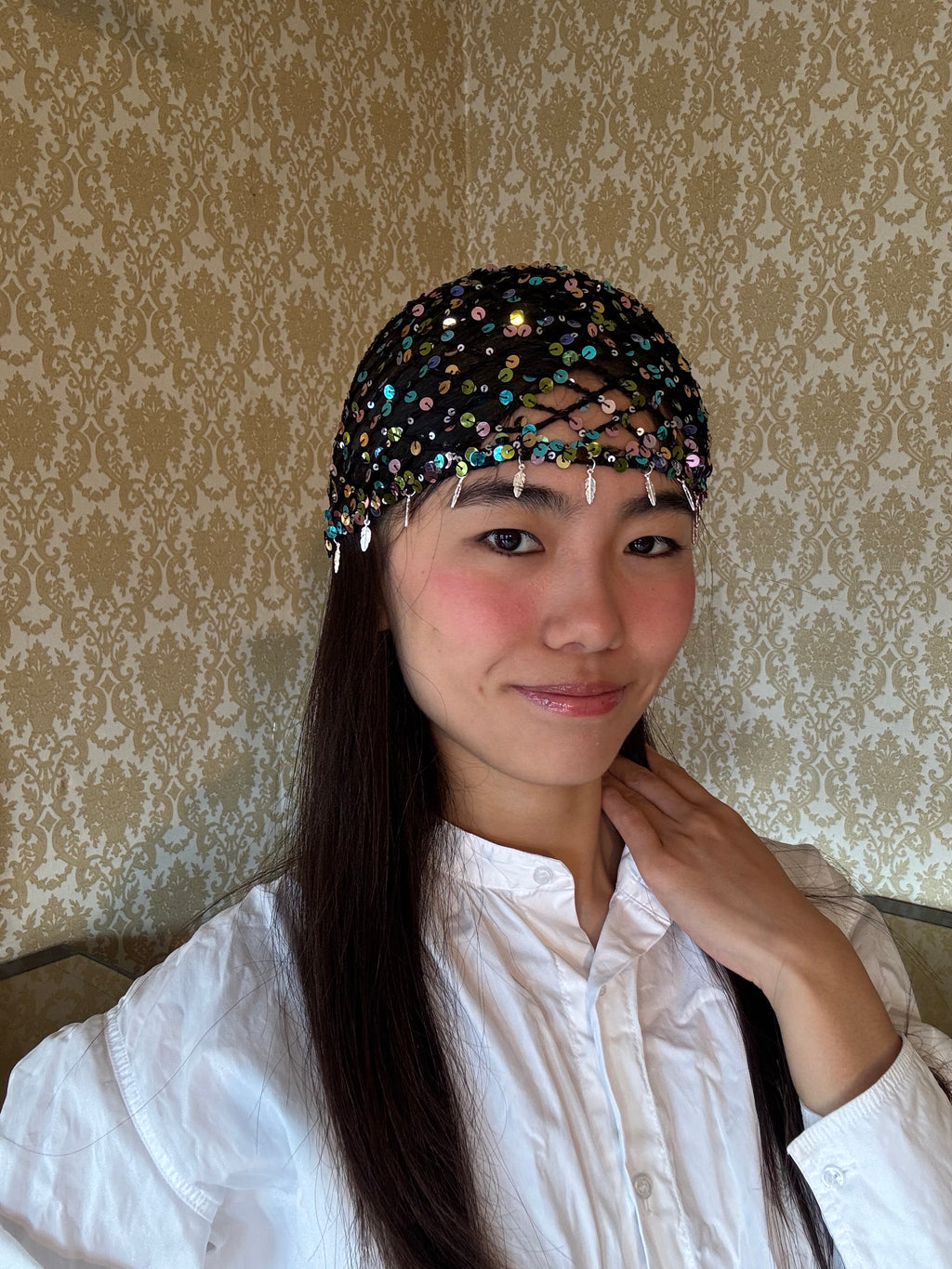 Crochet glittered mesh hat with feathers