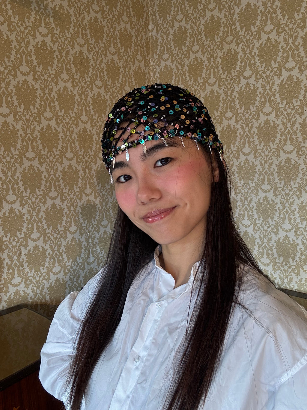 Crochet glittered mesh hat with feathers