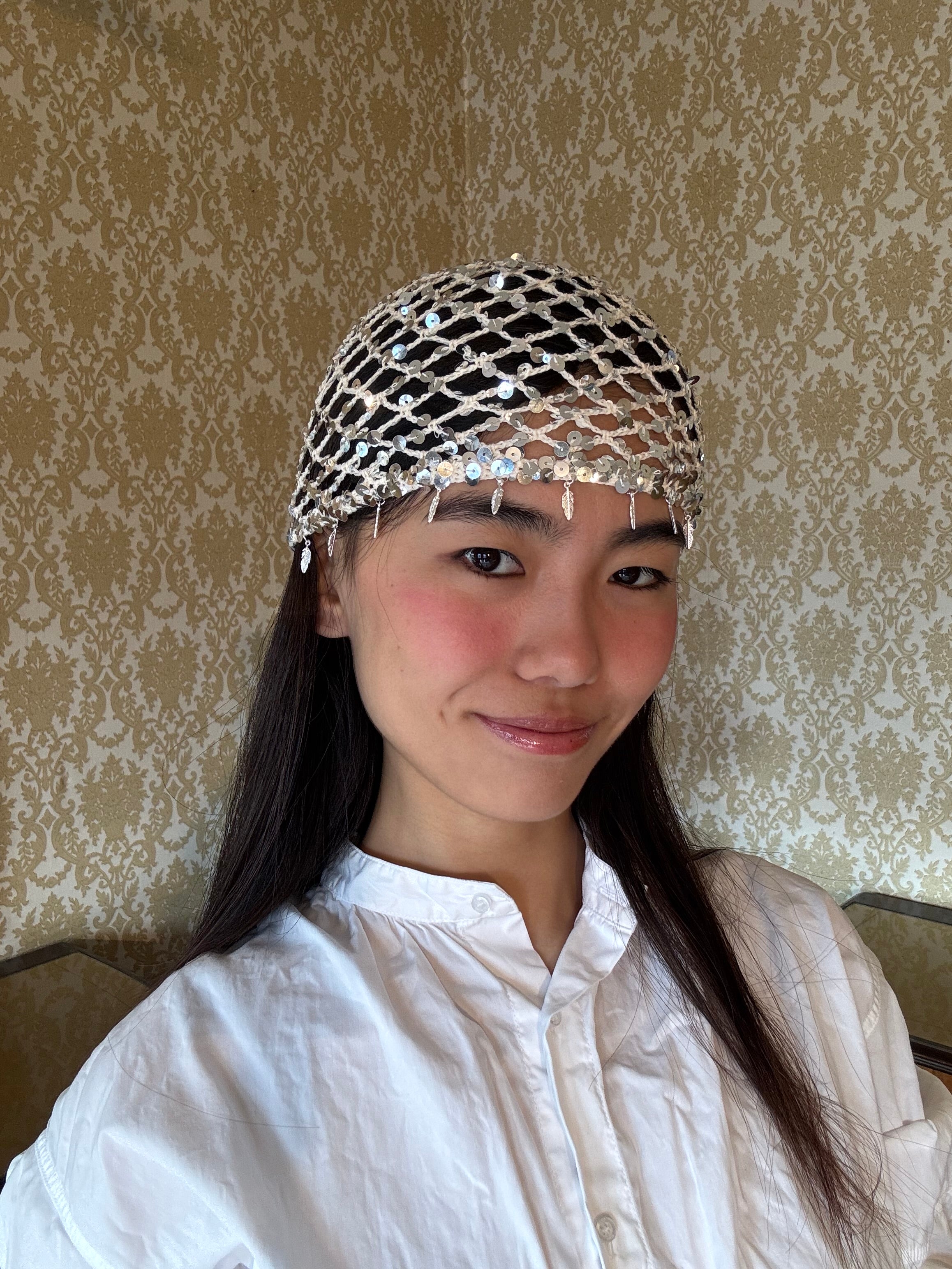 Crochet glittered mesh hat with feathers