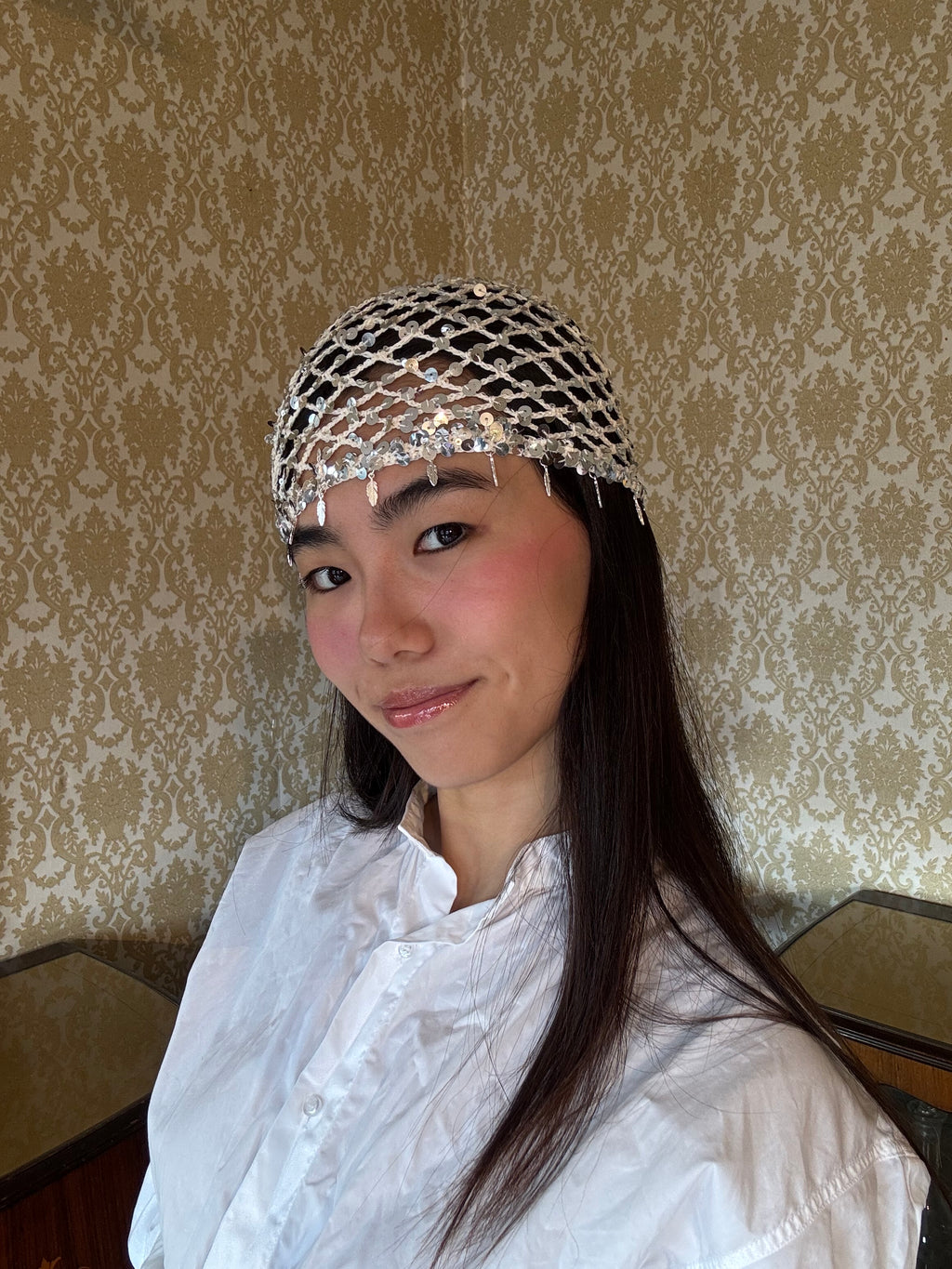 Crochet glittered mesh hat with feathers